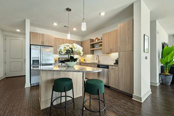 a kitchen with a large island with two stools